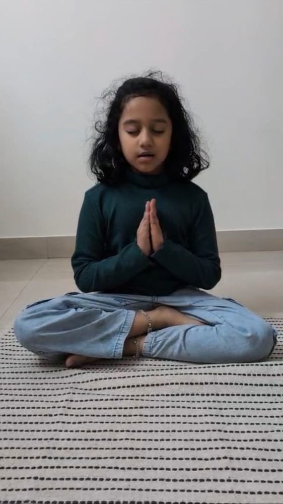 A girl meditating with folded hands and closed eyes