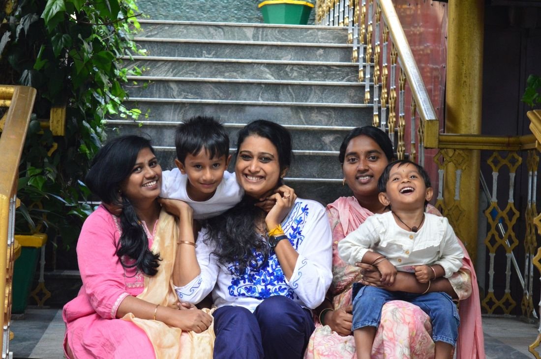 Mothers and children of the Sangha smiling together on temple steps